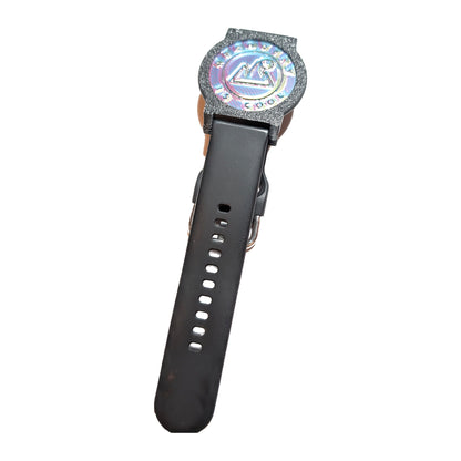 Recovewrist milestone band and bezel holding an iridescent “Recovery Is Cool” recovery coin on a black wristband, made in Colorado