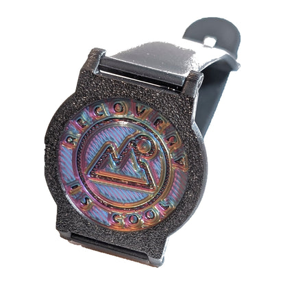 Close-up of a Recovewrist 3D-printed bezel and iridescent recovery milestone coin on a black band