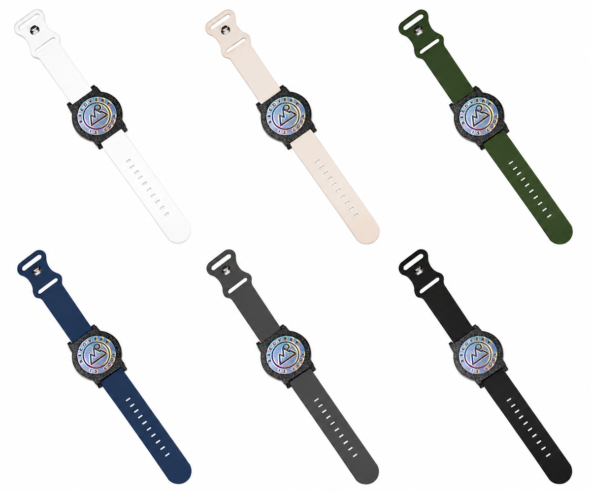 Six assembled Recovewrist milestone watches in a row, one per band color, each with the iridescent ‘Recovery Is Cool’ coin in a speckled bezel — made in Colorado