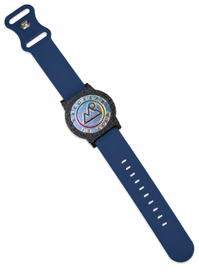 Recovewrist milestone band in navy blue, worn watch-style with the iridescent ‘Recovery Is Cool’ recovery coin in a speckled granite bezel — made in Colorado
